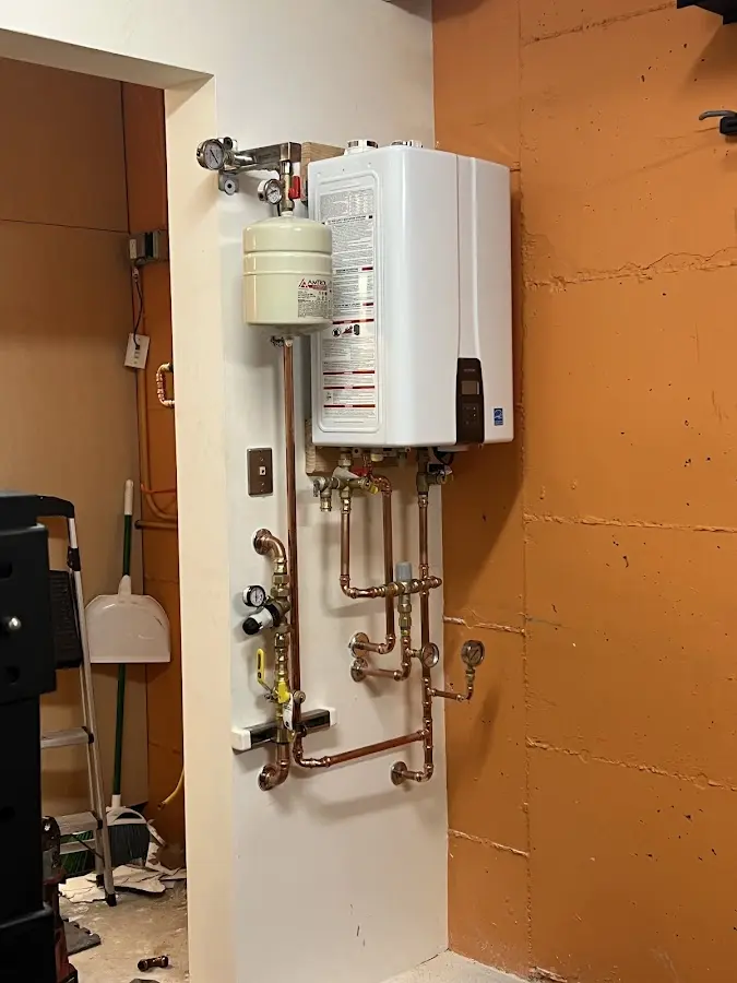 Plumbing technician inspecting water heater connections in Hinsdale